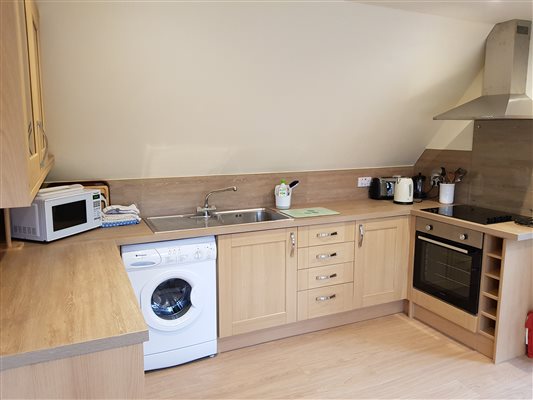 Self-catering cottage kitchen with washing machine, microwave, hob, oven and kettle